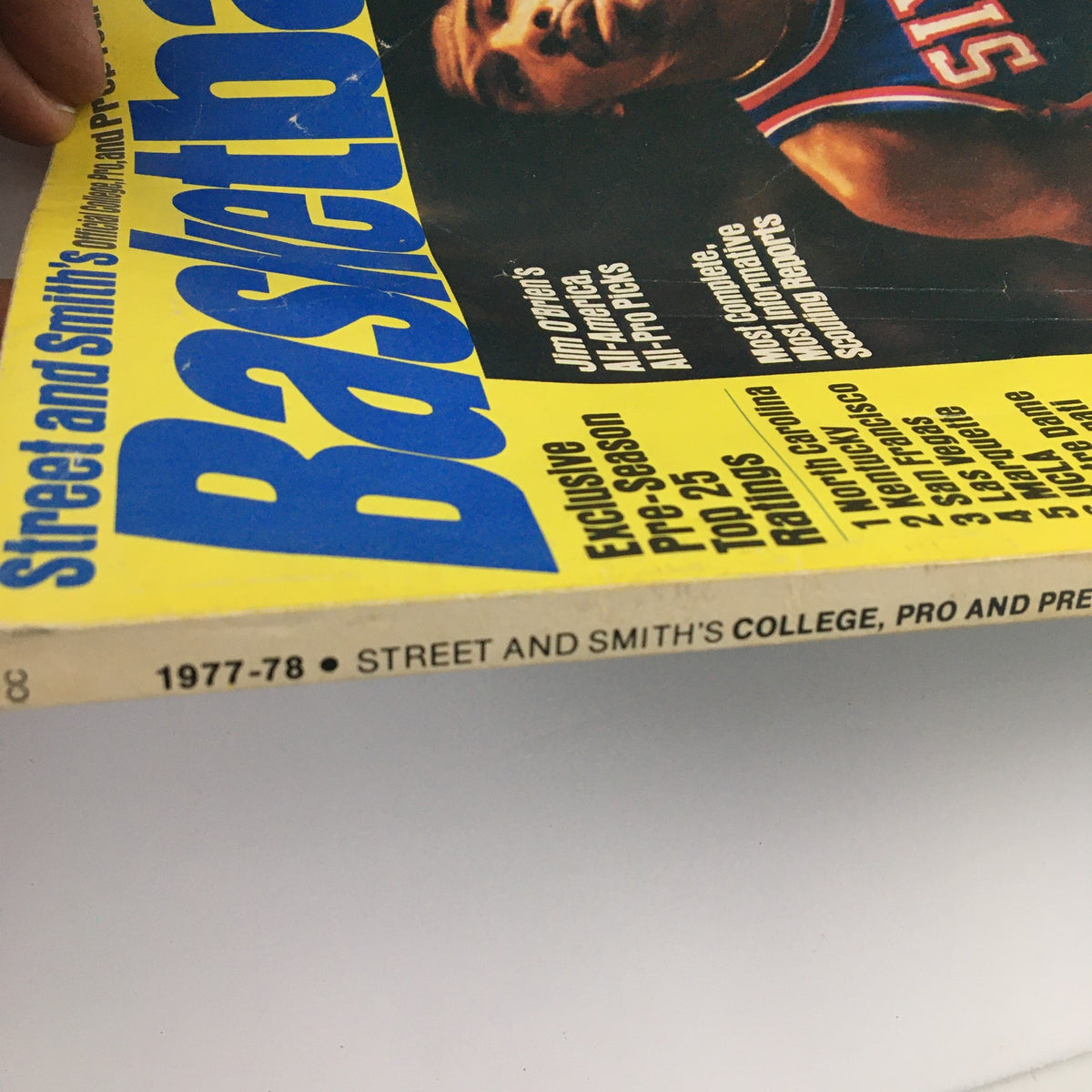 Angle shot of Street & Smith's Official College, Pro & Prep Yearbook 1977-1978 focusing on the title 'Basketball' and mentioning exclusive pre-season ratings of top college teams.