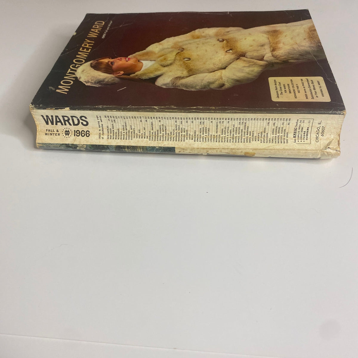 Side view of the 1966 Montgomery Ward Fall and Winter Catalog, highlighting its spine and some vintage design elements.
