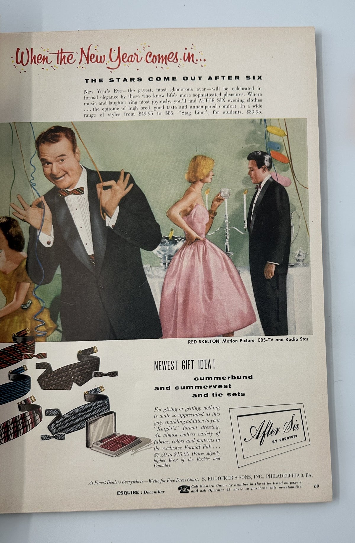 Esquire Magazine December 1955 featuring a festive New Year celebration scene with Red Skelton, showcasing elegant fashion in a formal setting, alongside an advertisement for gift ideas like cummerbunds and tie sets.