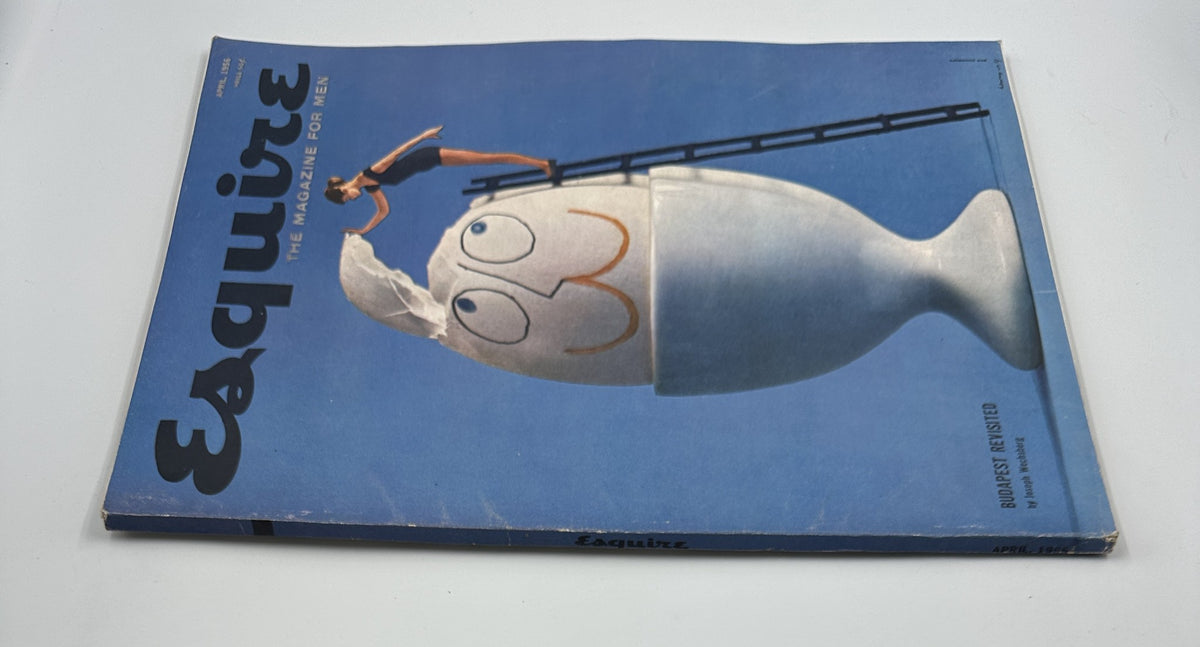 Alternative view of the cover of Esquire Magazine April 1956 displaying the playful design of an egg with a smile and a woman with a towel, accompanied by the title and the article 'Budapest Revisited'.