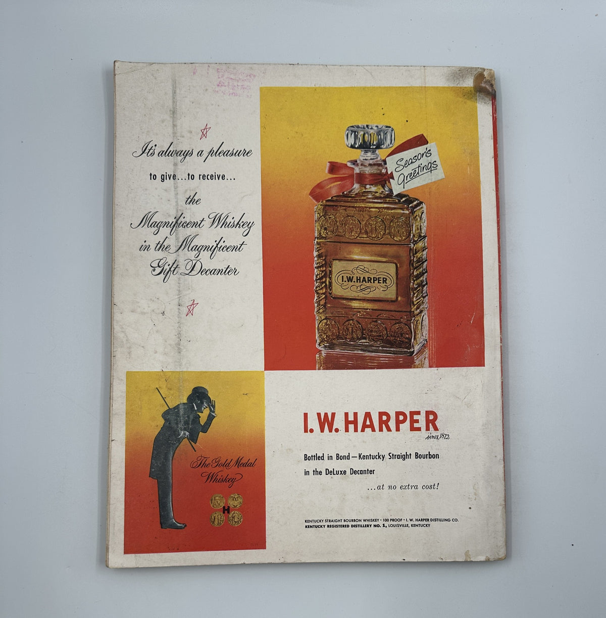Back cover of Esquire Magazine December 1950 displaying I.W. Harper whiskey advertisement. The design includes a seasonal greeting and highlights the whiskey's unique presentation.