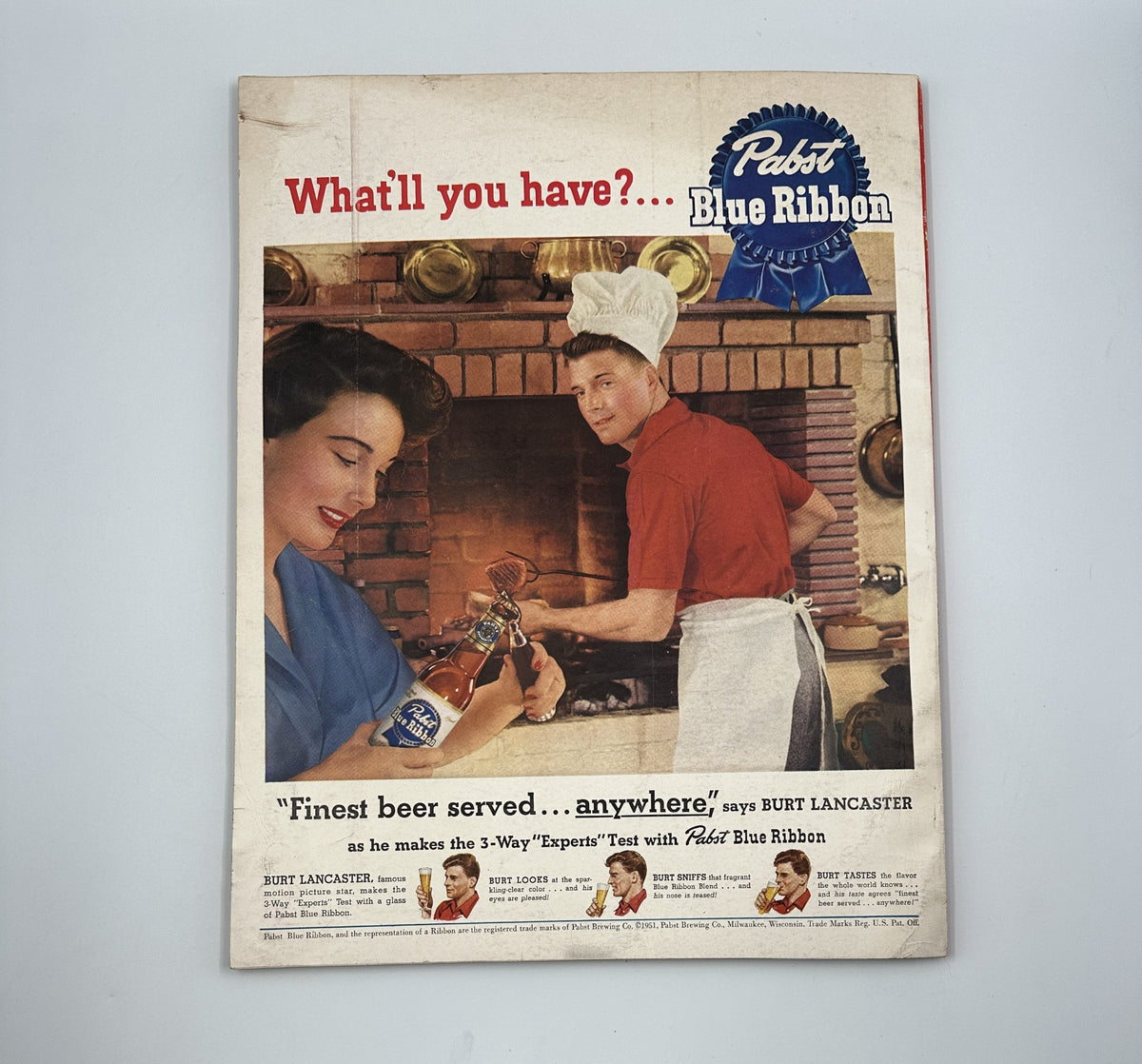 Esquire Magazine July 1951 advertisement for Pabst Blue Ribbon, featuring Burt Lancaster wearing a chef's hat, promoting the brand with the tagline 'Finest beer served... anywhere'.