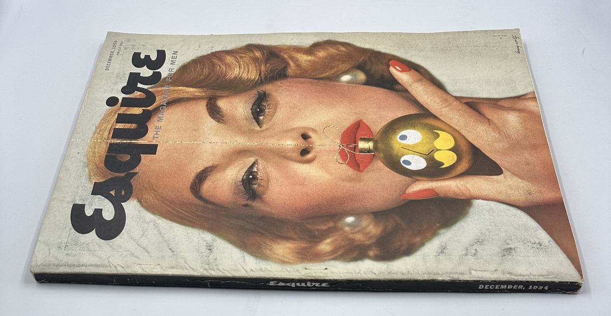 December 1954 Esquire Magazine showcasing a stylish model with a playful Christmas ornament, emphasizing retro design and festive vibes.