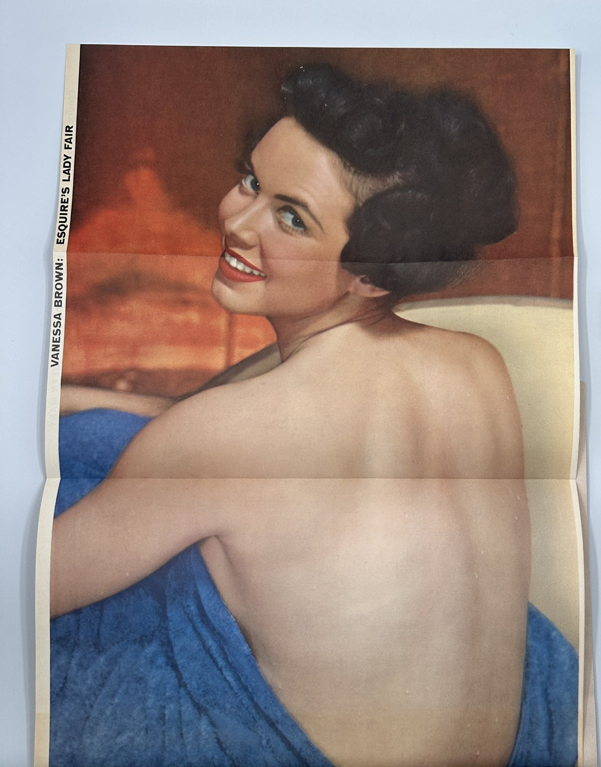 Pinup foldout of Vanessa Brown in Esquire Magazine August 1954, showcasing her smiling and wearing a blue wrap.