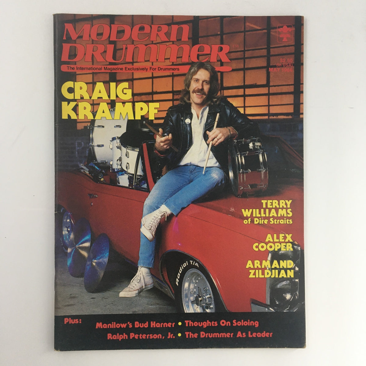 Cover of Modern Drummer Magazine from May 1986 featuring Craig Krampf, with a backdrop of drums and a classic car, promoting interviews with Terry Williams, Alex Cooper, and more.