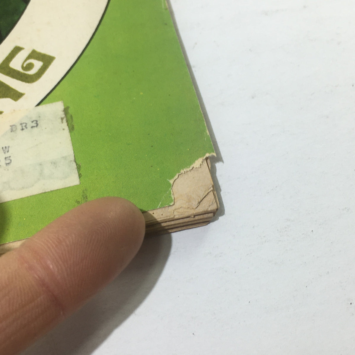Close-up of the edge of Cue Magazine from June 6, 1970, showing wear and tear, including a torn corner and an address label, while emphasizing the magazine's vintage condition.