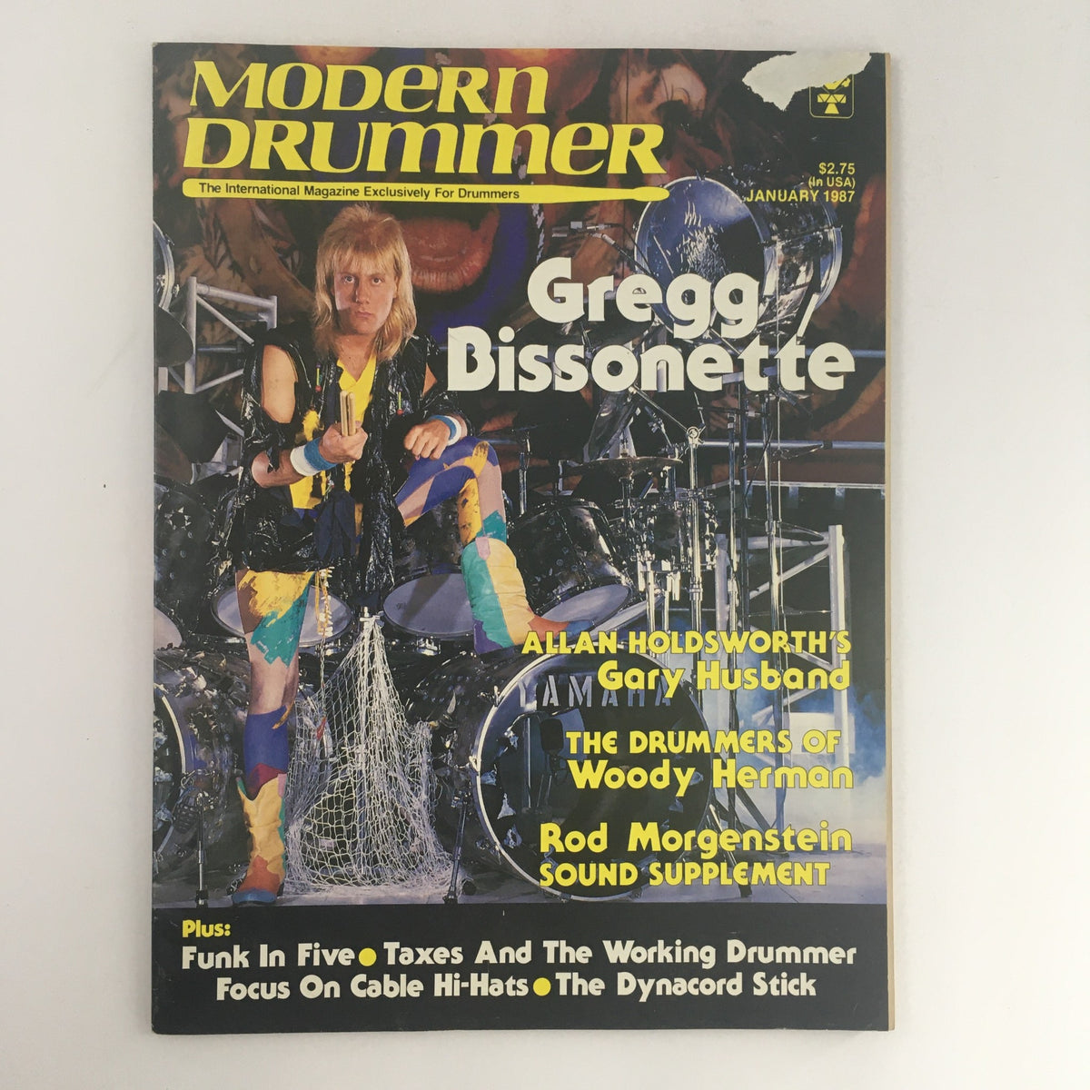 Modern Drummer Magazine January 1987 featuring Gregg Bissonette on the cover, showcasing vibrant drumming imagery with colorful drum kit and musical elements.