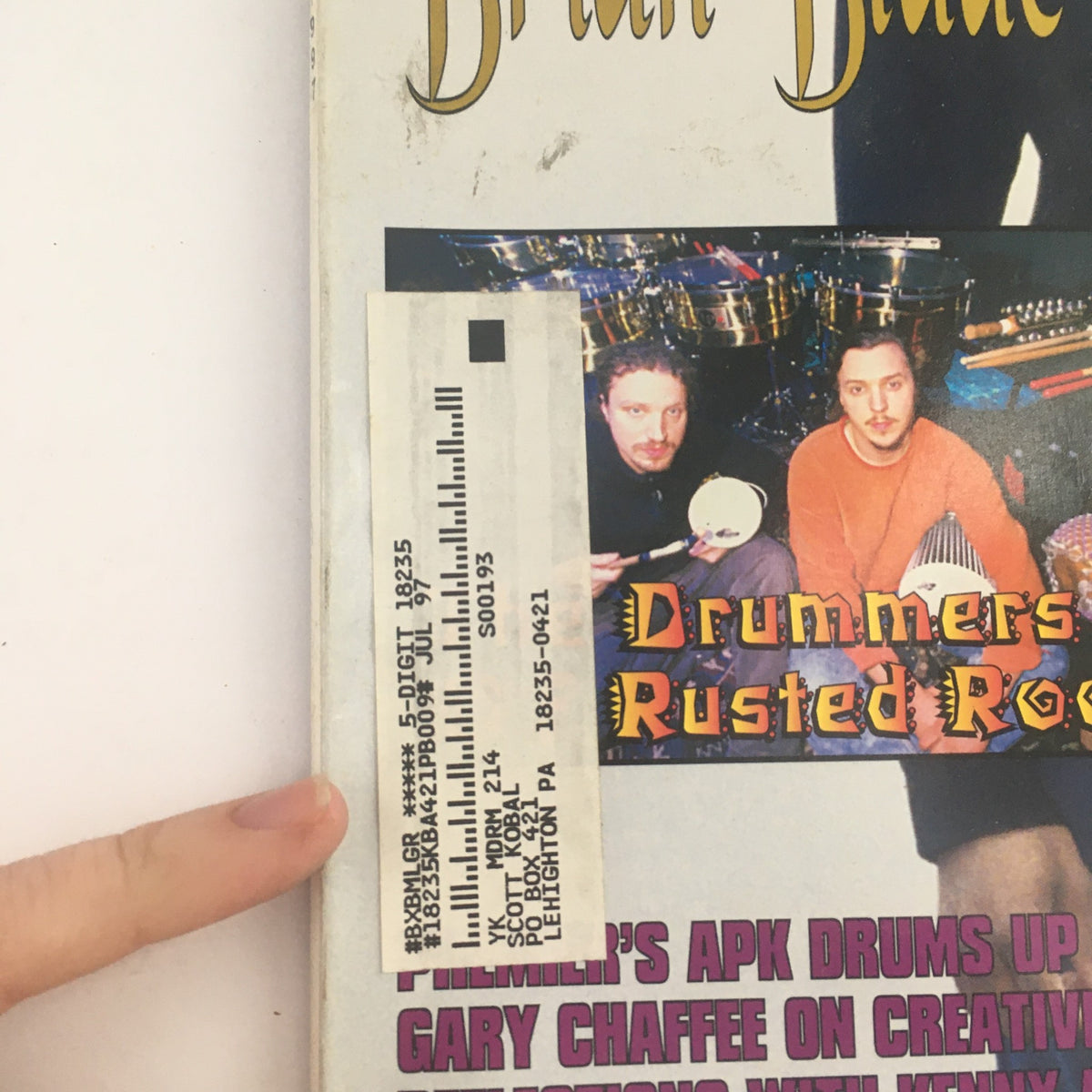 Close-up of the Modern Drummer Magazine May 1997 cover, focusing on the section highlighting Rusted Root drummers. Includes a price tag and details of featured articles, making it a collectible for music fans.