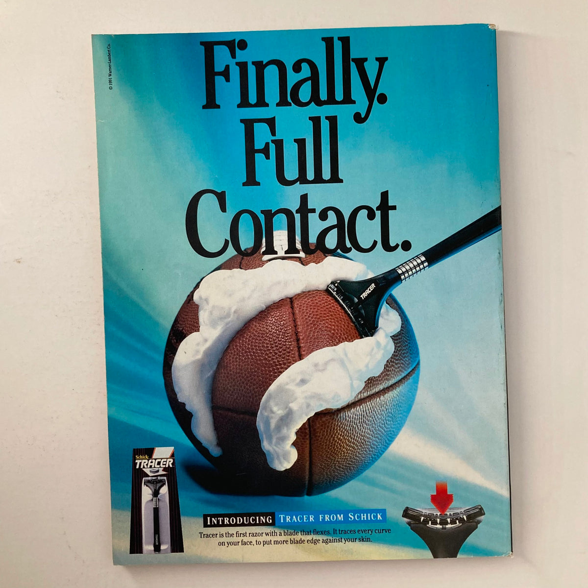 Back cover of Joe Weider's Muscle & Fitness Magazine October 1991 with an advertisement for Tracer from Schick, featuring a football and razor illustration.