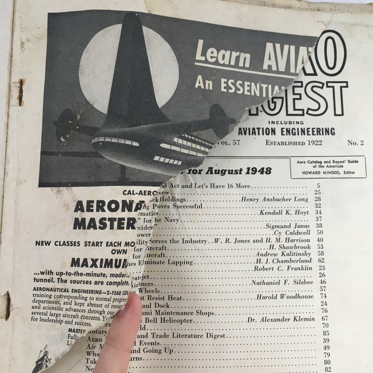 Close-up of damaged page from Aero Digest August 1948, revealing article titles and historical context related to aviation engineering.