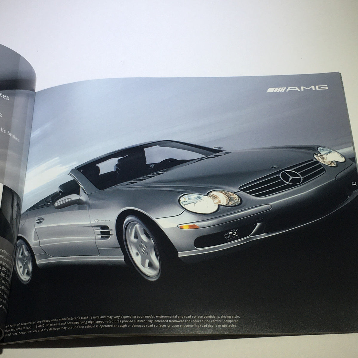 2004 Mercedes-Benz SL-Class 500 600 AMG Dealership Car Auto Brochure Catalog showcasing the luxurious silver AMG model parked with a dramatic city backdrop.