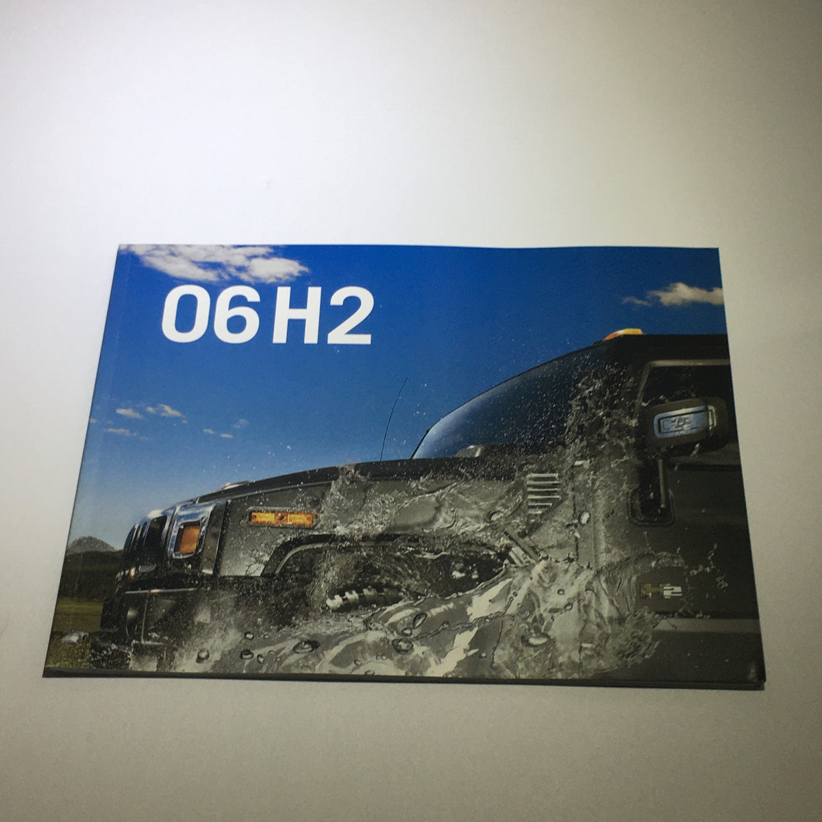 Cover page of the 2006 Hummer H2 SUV SUT Dealership Car Auto Brochure Catalog featuring a black Hummer driving through water.