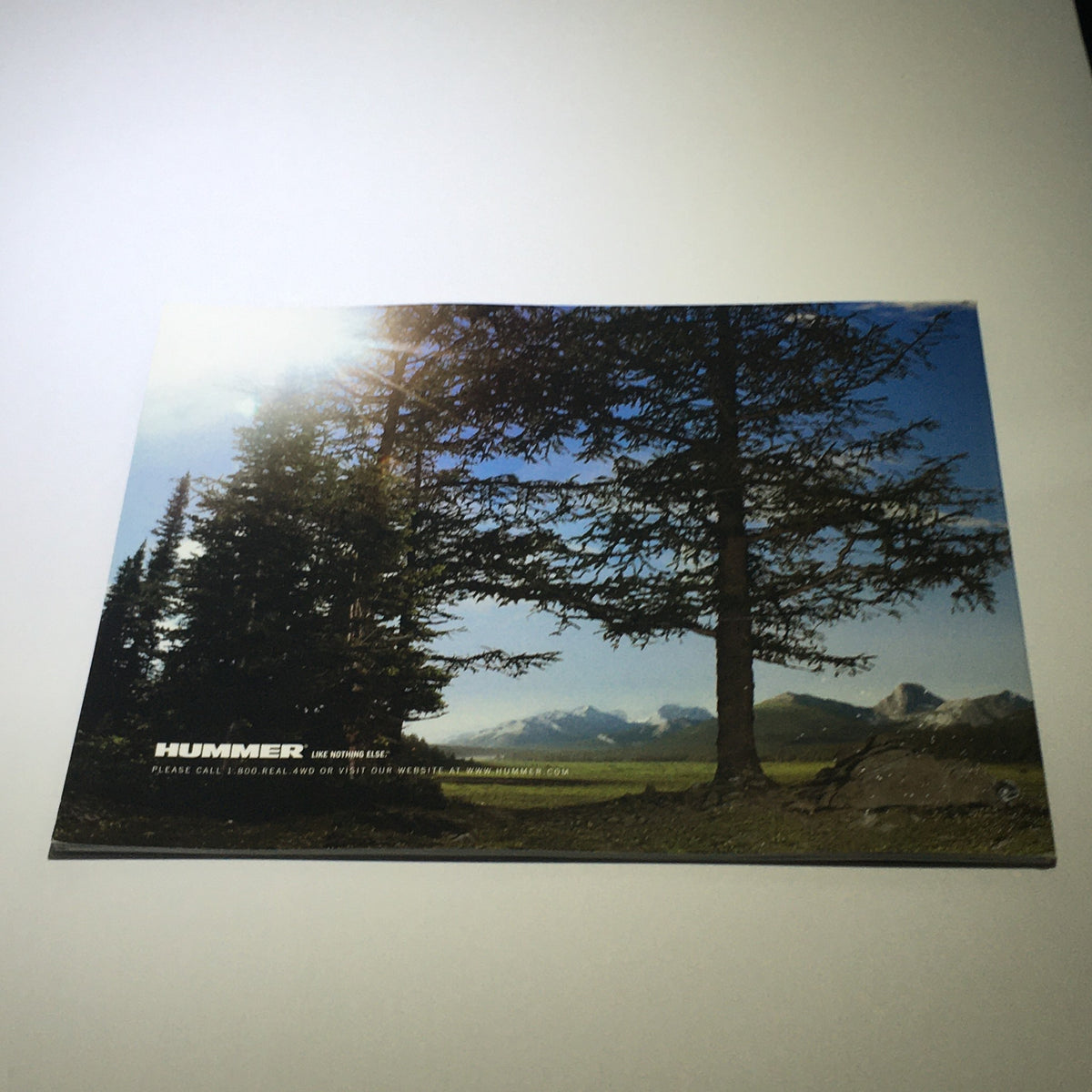 Back cover of the 2006 Hummer H2 SUV SUT Dealership Car Auto Brochure Catalog featuring scenic mountains and trees, representing the Hummer brand.