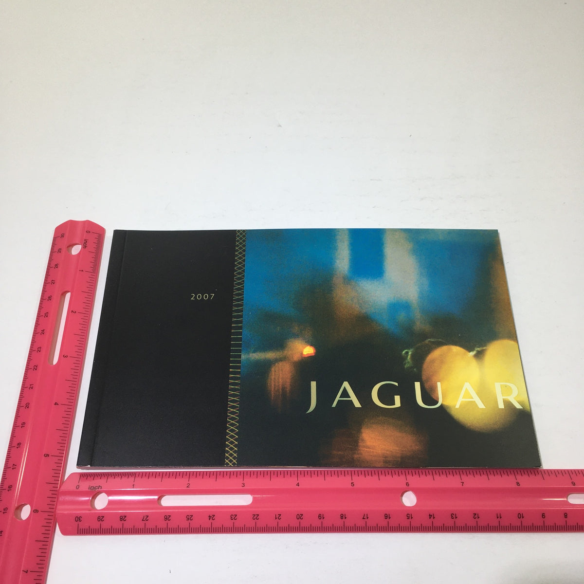2007 Jaguar PG 28 Dealership Car Auto Brochure Catalog displayed with a pink ruler for size reference, showcasing an artistic design.