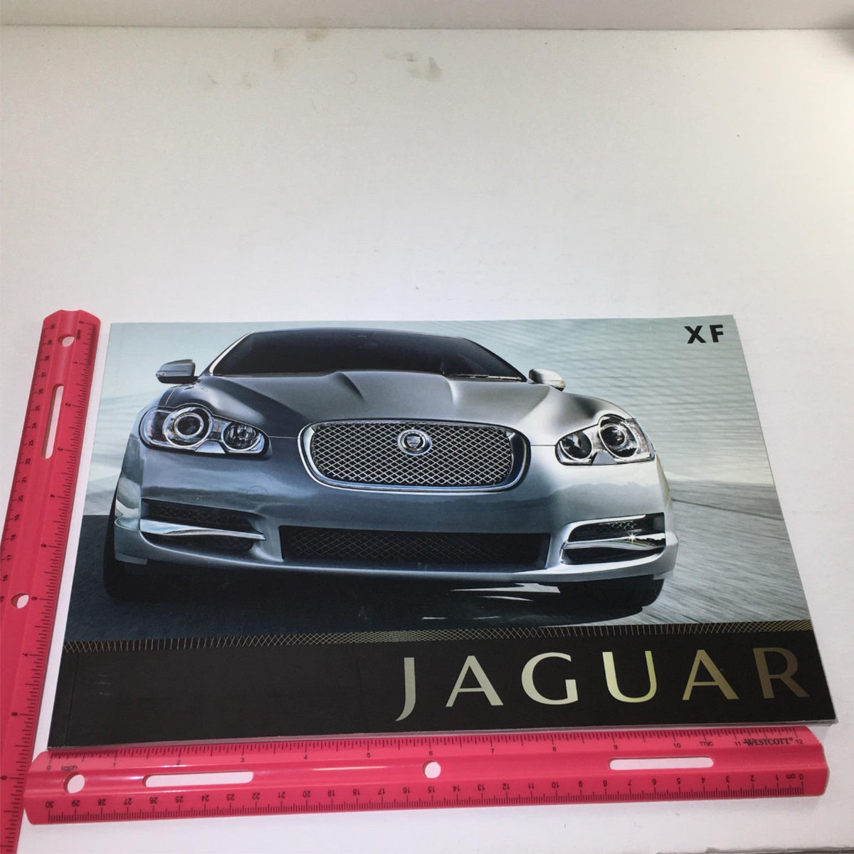 2009 Jaguar XF Dealership Car Auto Brochure Catalog displaying the front view of the silver Jaguar XF, highlighting its distinctive grille and stylish headlights.