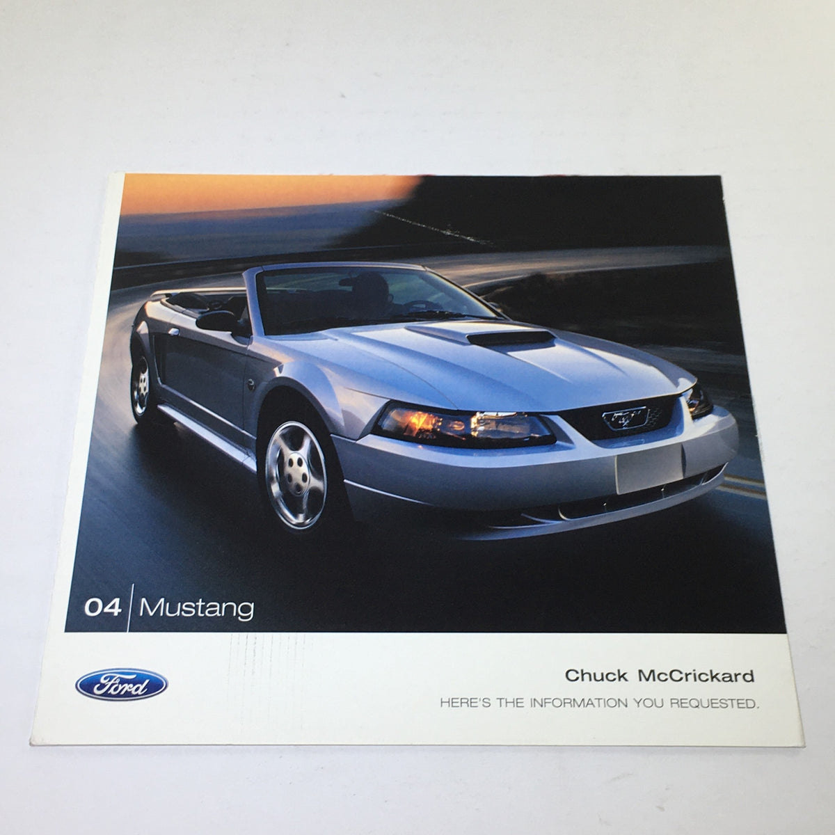 2004 Ford Mustang Muscle Chuck McCrickard Dealership Car Auto Brochure Catalog cover showcasing a sleek silver Mustang convertible driving on a highway.