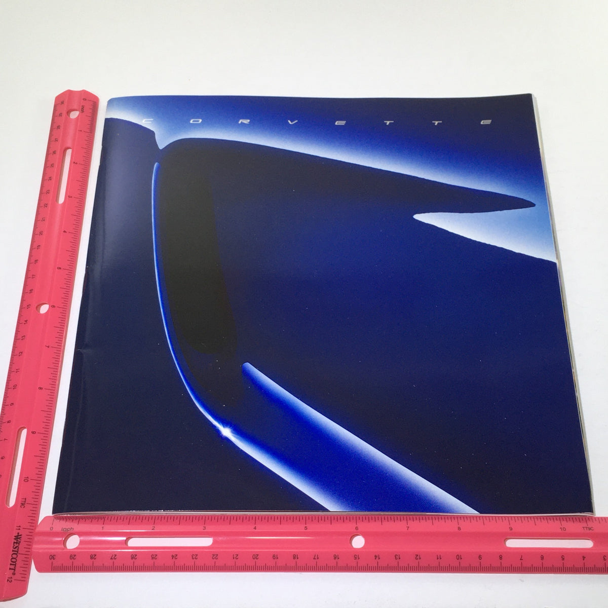 2004 Chevrolet Corvette Dealership Car Auto Brochure cover displayed with a ruler for size reference, emphasizing the brochure's dimensions.