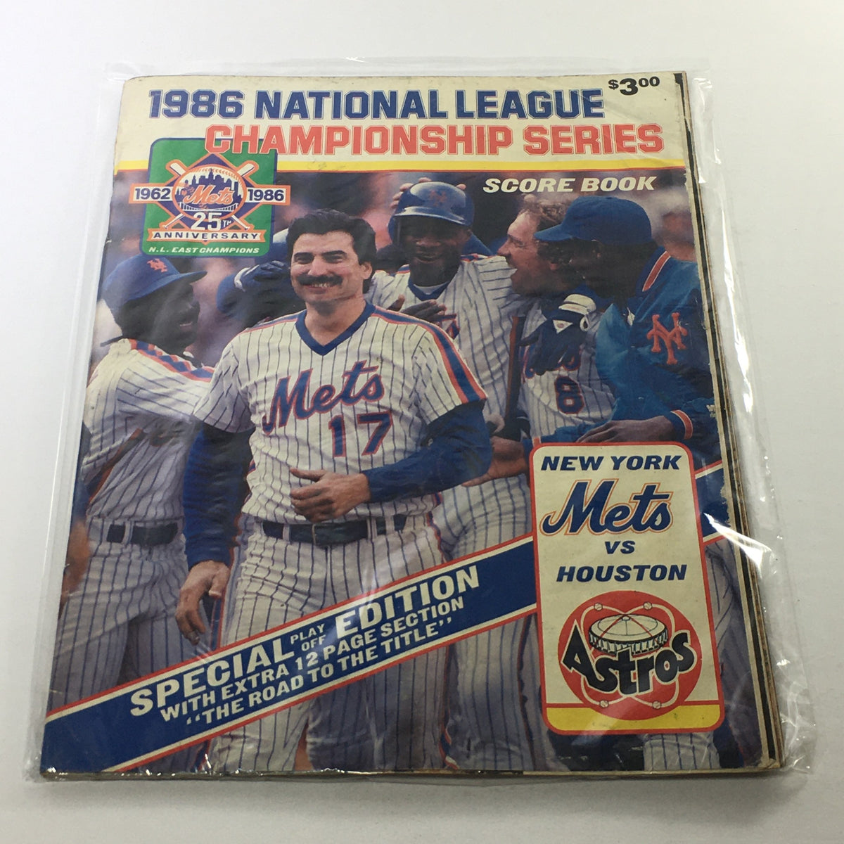Cover of the 1986 National League Championship Series magazine featuring the New York Mets vs Houston Astros, showcasing a team celebration with players in traditional Mets uniforms. Special edition scorebook commemorating the pivotal matches in baseball history.
