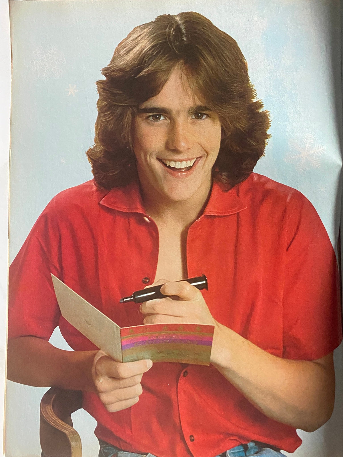 Black and white photo of a young male celebrity smiling while writing in a card, showcase in the December 1980 issue of Tiger Beat Magazine featuring Matt Dillon.