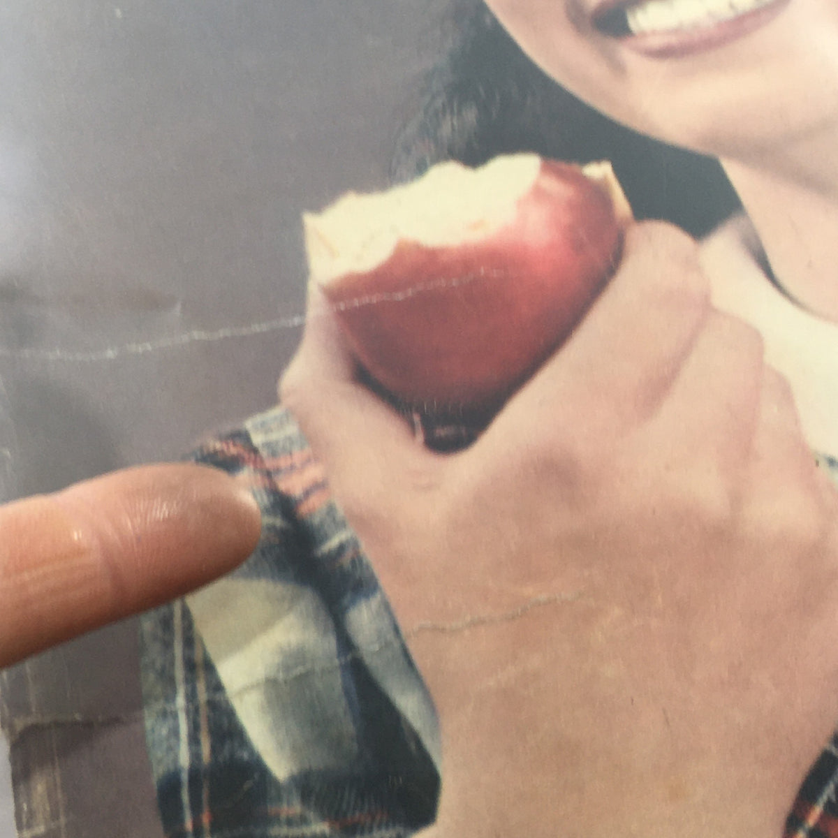 Close-up image of Look Magazine: August 22, 1944 cover showing a smiling girl holding an apple with a focus on her hand and the magazine's striking visuals.