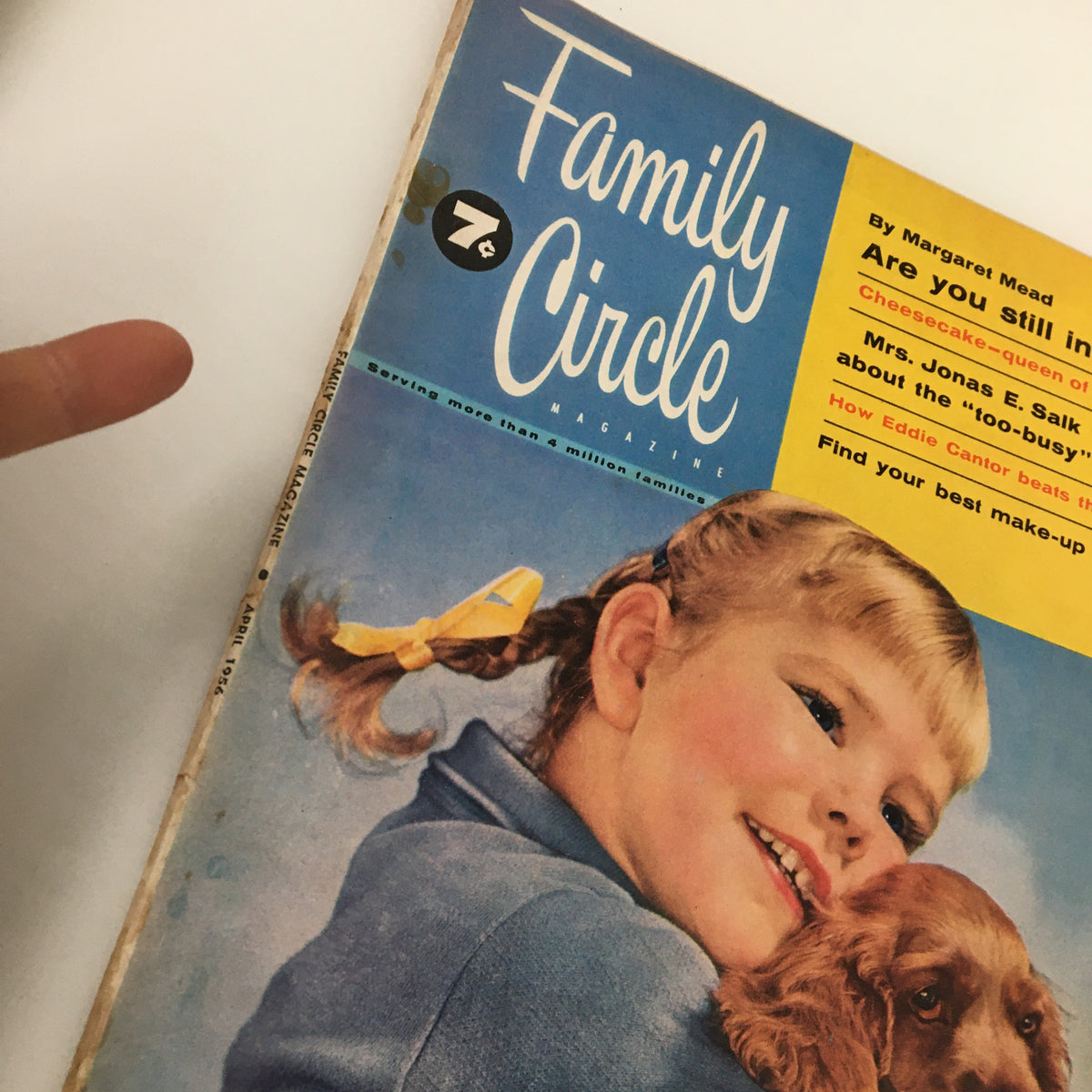 Close-up of the cover of the VTG Family Circle Magazine from April 1956 showing a girl holding a puppy and the magazine header 'Family Circle'.