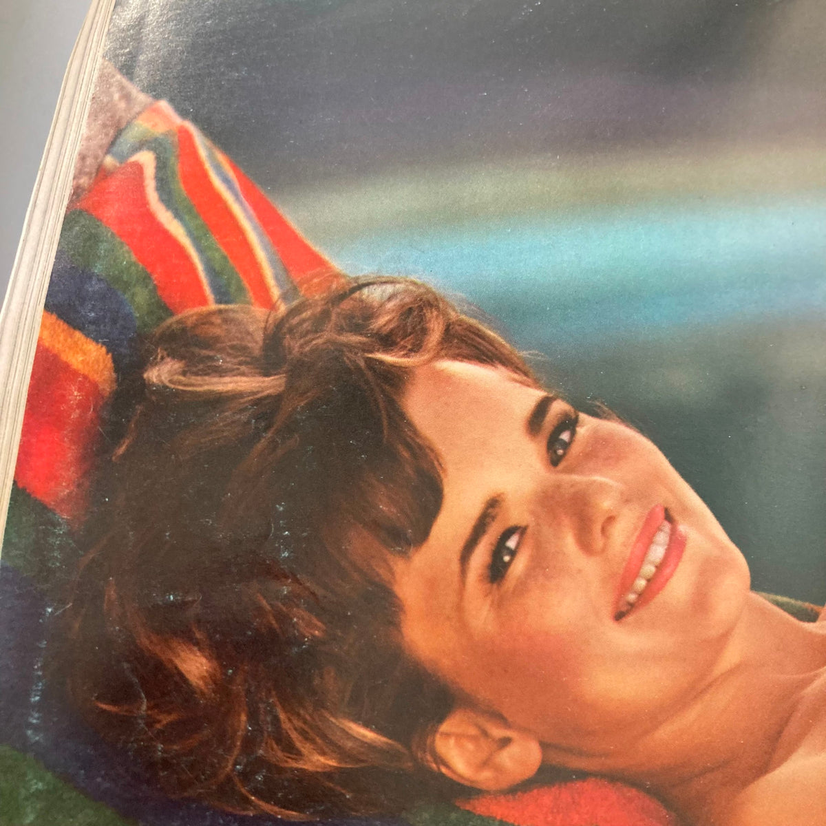 Close-up of the centerfold from the VTG Playboy Magazine June 1966, featuring a smiling woman with beautiful hair and colorful background.