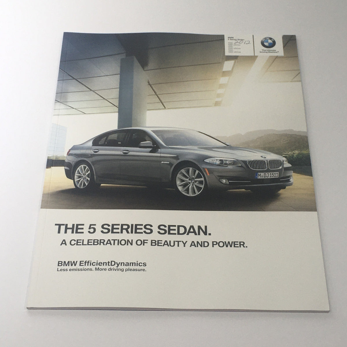 2012 BMW 5 Series Sedan brochure cover showcasing vehicle design, highlighting beauty and power.