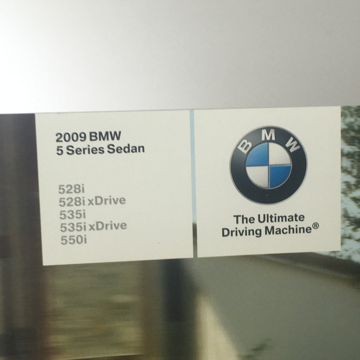 Close-up of the 2009 BMW 5 Series Sedan brochure showing the model details including 528i, 535i, and 550i with the BMW logo.