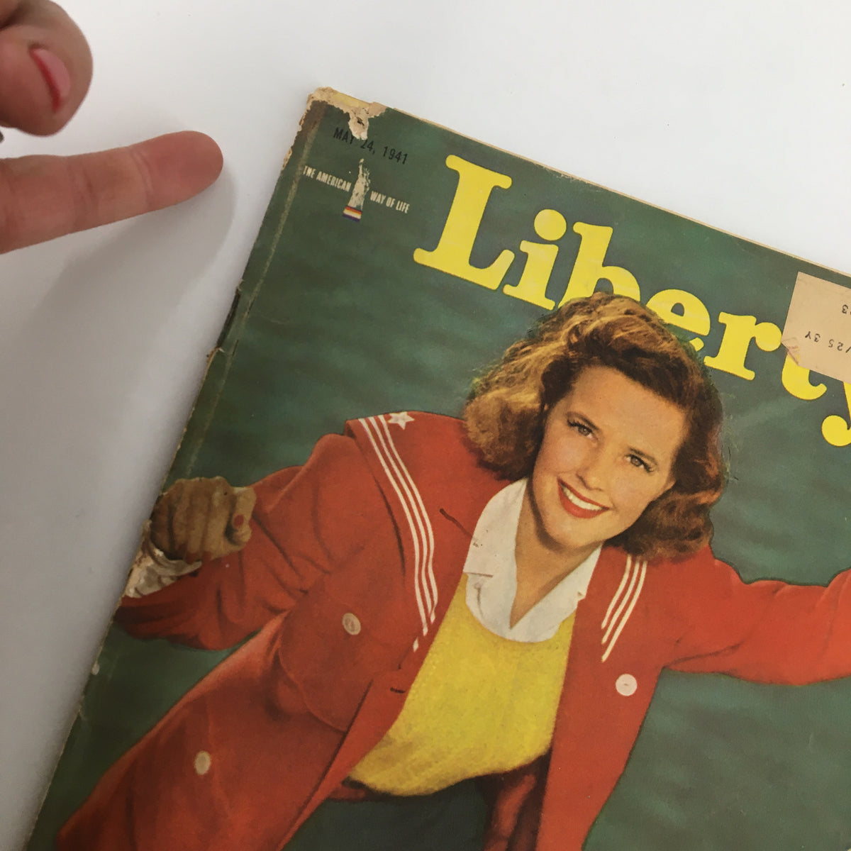 Close-up image of the cover of VTG Liberty Magazine from May 24, 1941, showing the title "Liberty" and a smiling woman in a red jacket, highlighting vintage design elements.