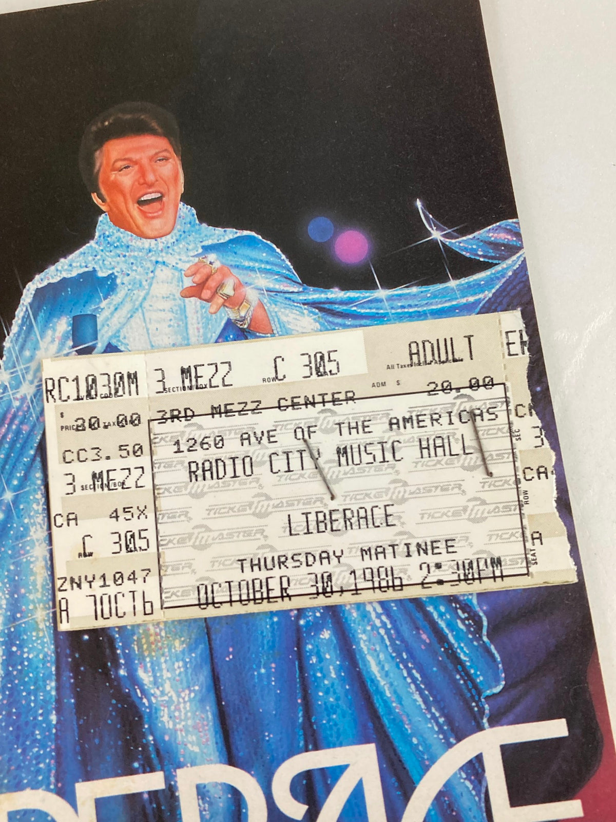 Close-up view of the 1986 Radio City Music Hall Program displaying Liberace and ticket details for the performance with The Rockettes and Dancing Waters.