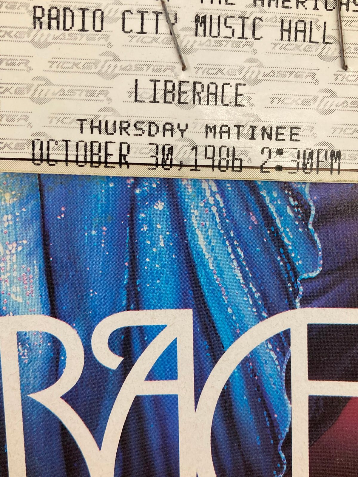 Close-up image of a ticket stub from the 1986 Radio City Music Hall Program featuring Liberace, showing details of the Thursday matinee performance on October 30, 1986, highlighting the venue and event.