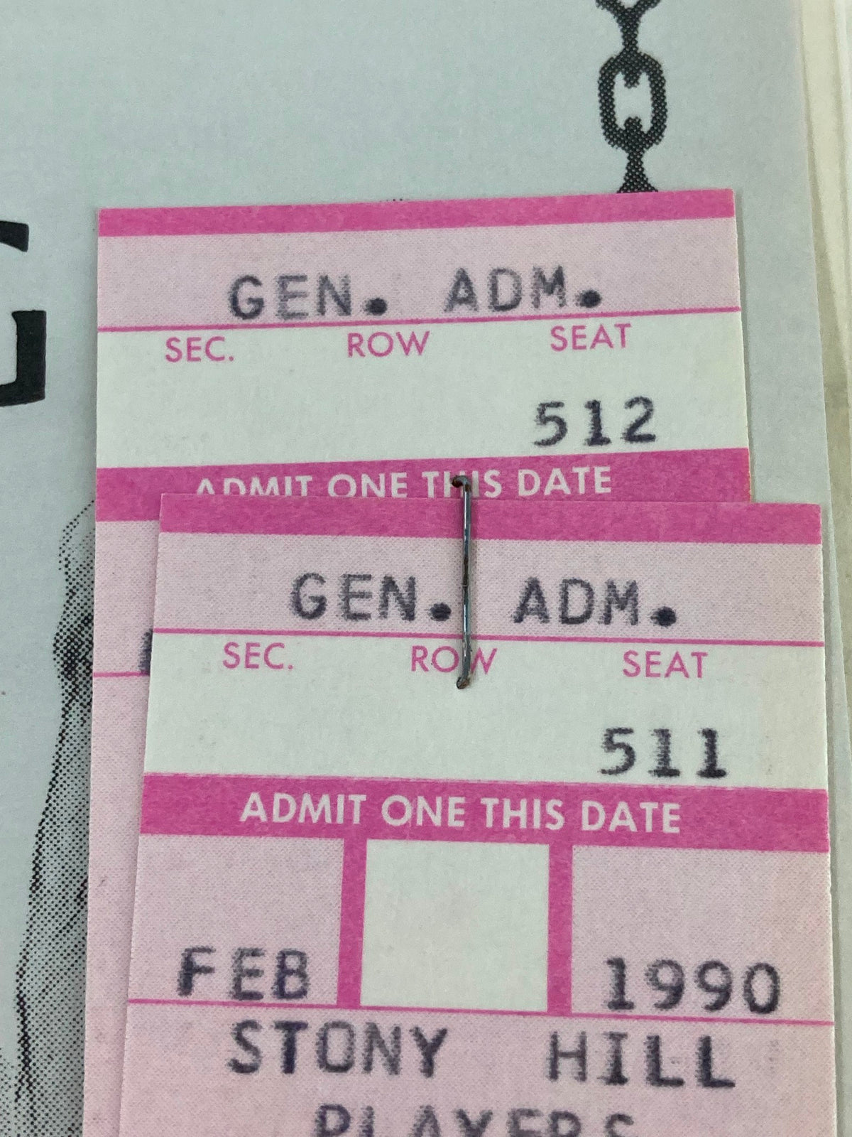Close-up of ticket stubs from the 1990 Stony Hill Players program for 'The Lady's Not For Burning,' showing section, row, and seat details.
