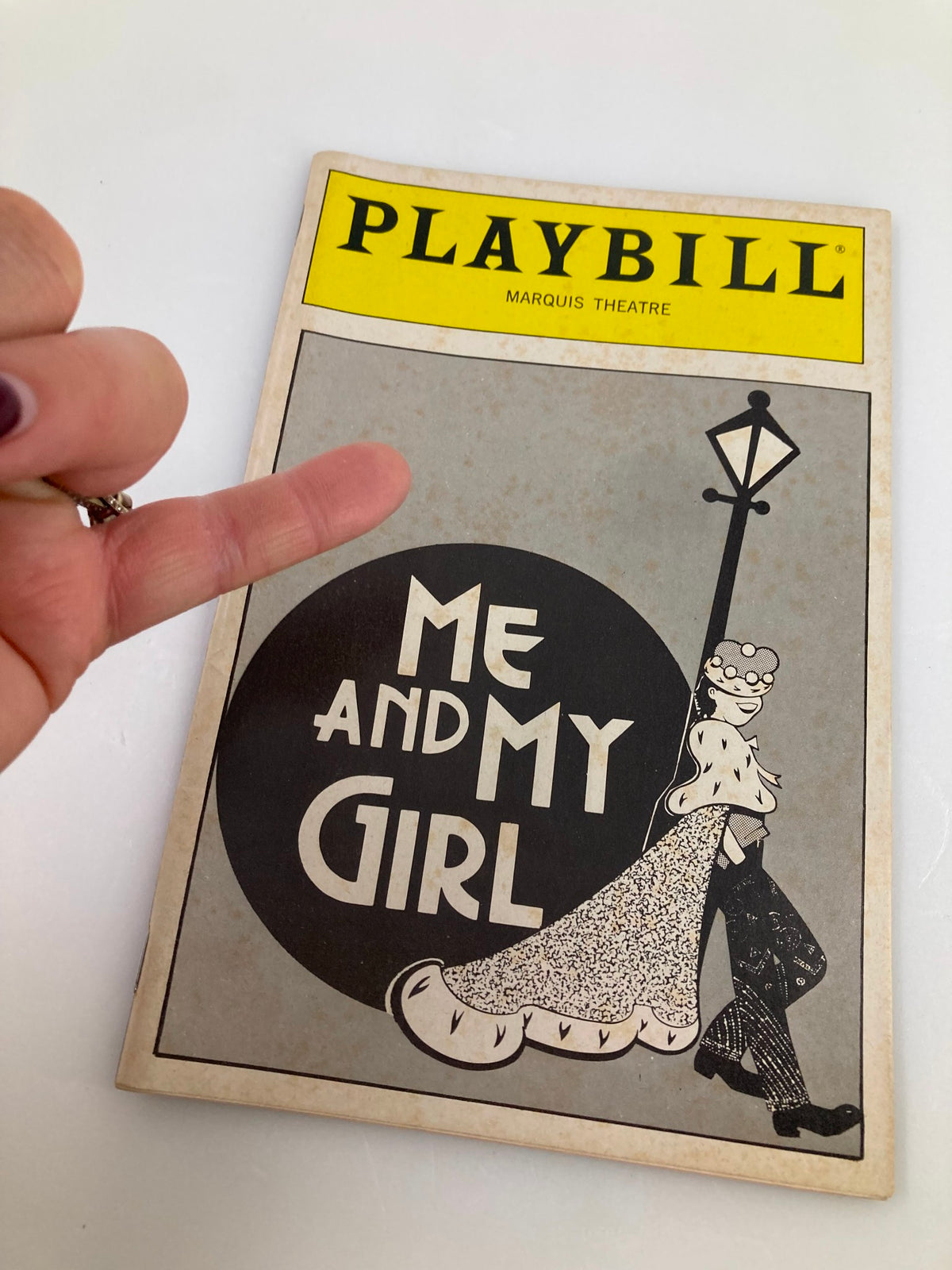 1989 Playbill for Me and My Girl at Marquis Theatre, featuring a hand holding the Playbill displaying the cover art.