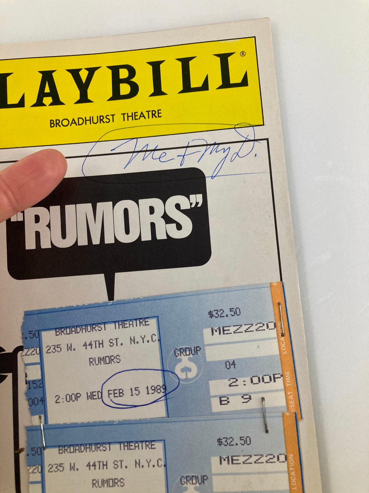 Close-up of the 1989 Playbill for 'Rumors' at the Broadhurst Theatre, showing cast tickets and a signature.