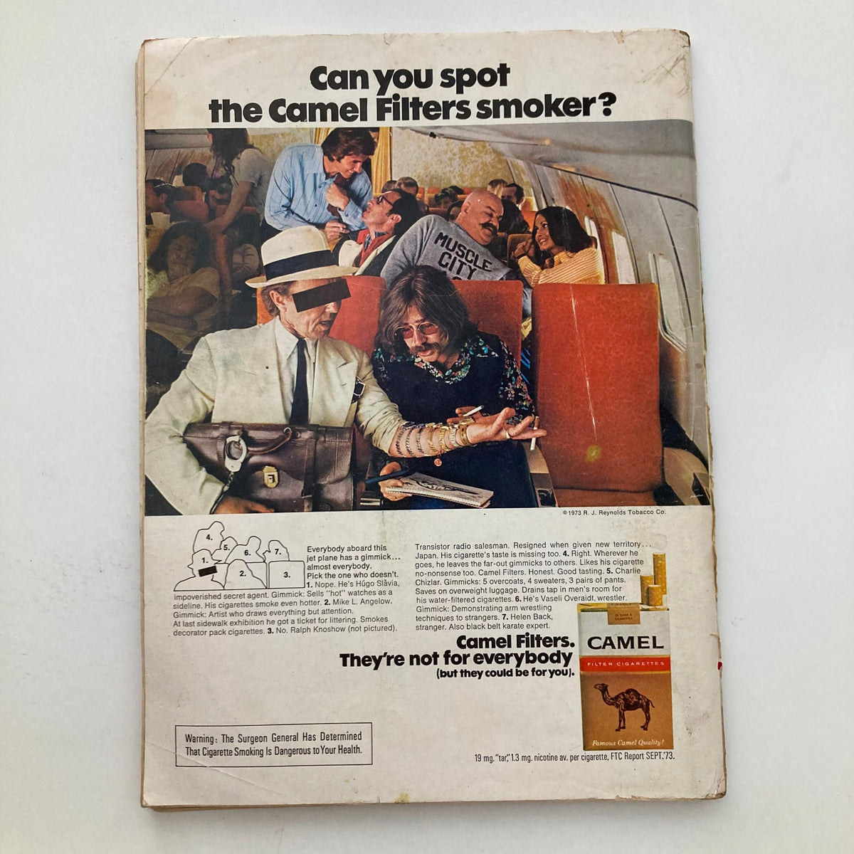 Back cover of the VTG Playboy Magazine February 1974 featuring an advertisement for Camel Filters cigarettes, showcasing a crowded airplane scene with passengers engaging in various activities.