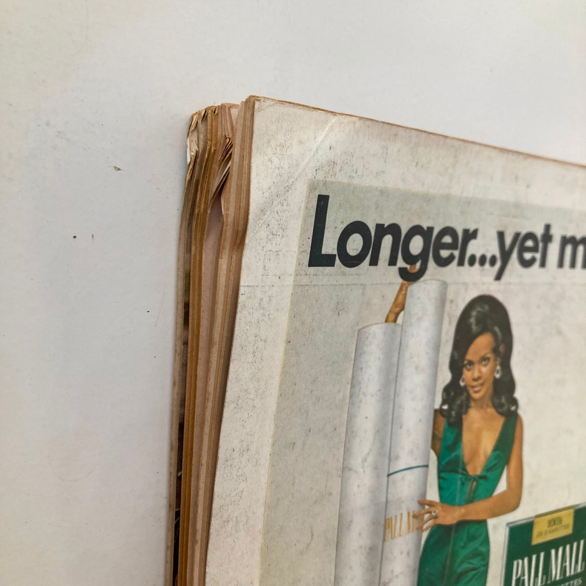 Close-up view of the spine of the VTG Playboy Magazine November 1969 featuring Claudia Jennings, displaying vintage wear and tear, highlighting the magazine's historical significance.