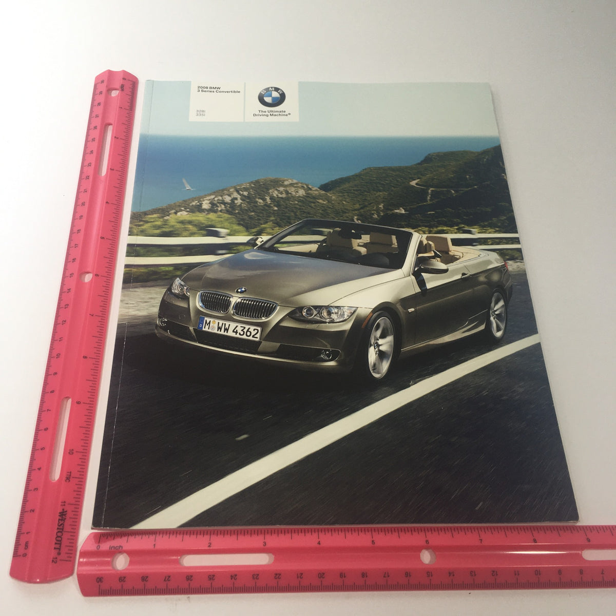 2008 BMW 3 Series Convertible 328i 335i auto brochure cover, featuring a BMW convertible on a scenic road with a ruler for size reference.
