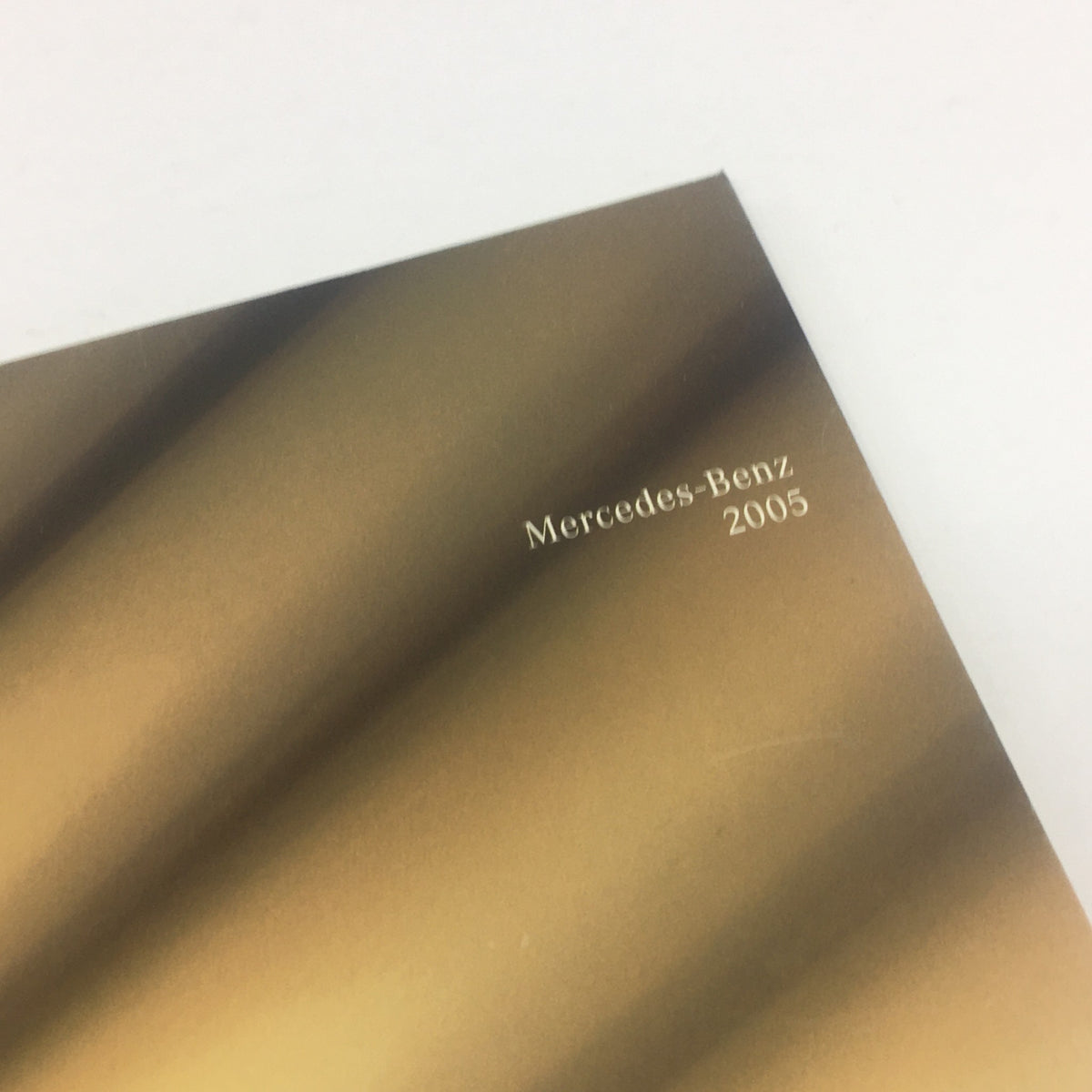 Close-up of the 2005 Mercedes-Benz C230 Dealership Car Auto Brochure Catalog showing the embossed 'Mercedes-Benz' logo and the year 2005.