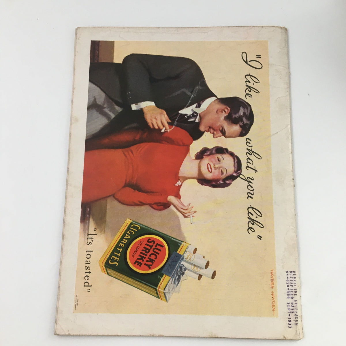 Vintage advertisement for Lucky Strike cigarettes, featuring a woman in a red dress and a man, emphasizing the retro aesthetic and cultural context of the early 20th century.