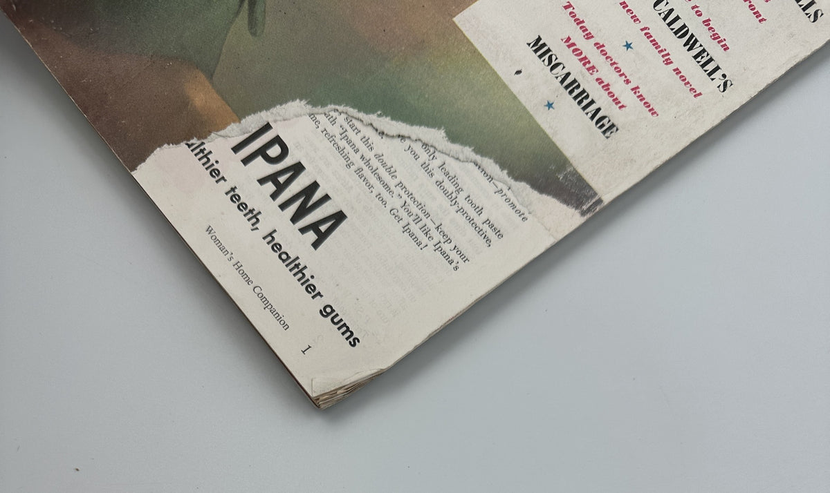 Detail shot of Woman’s Home Companion Magazine, November 1950, featuring a partially torn advertisement for IPANA toothpaste along with the visible title of the magazine.