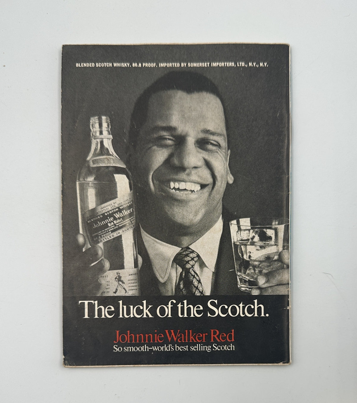 Advertisement from Jet Magazine featuring Johnnie Walker Scotch, with a man smiling while holding a bottle and glass, illustrated with the slogan 'The luck of the Scotch'.