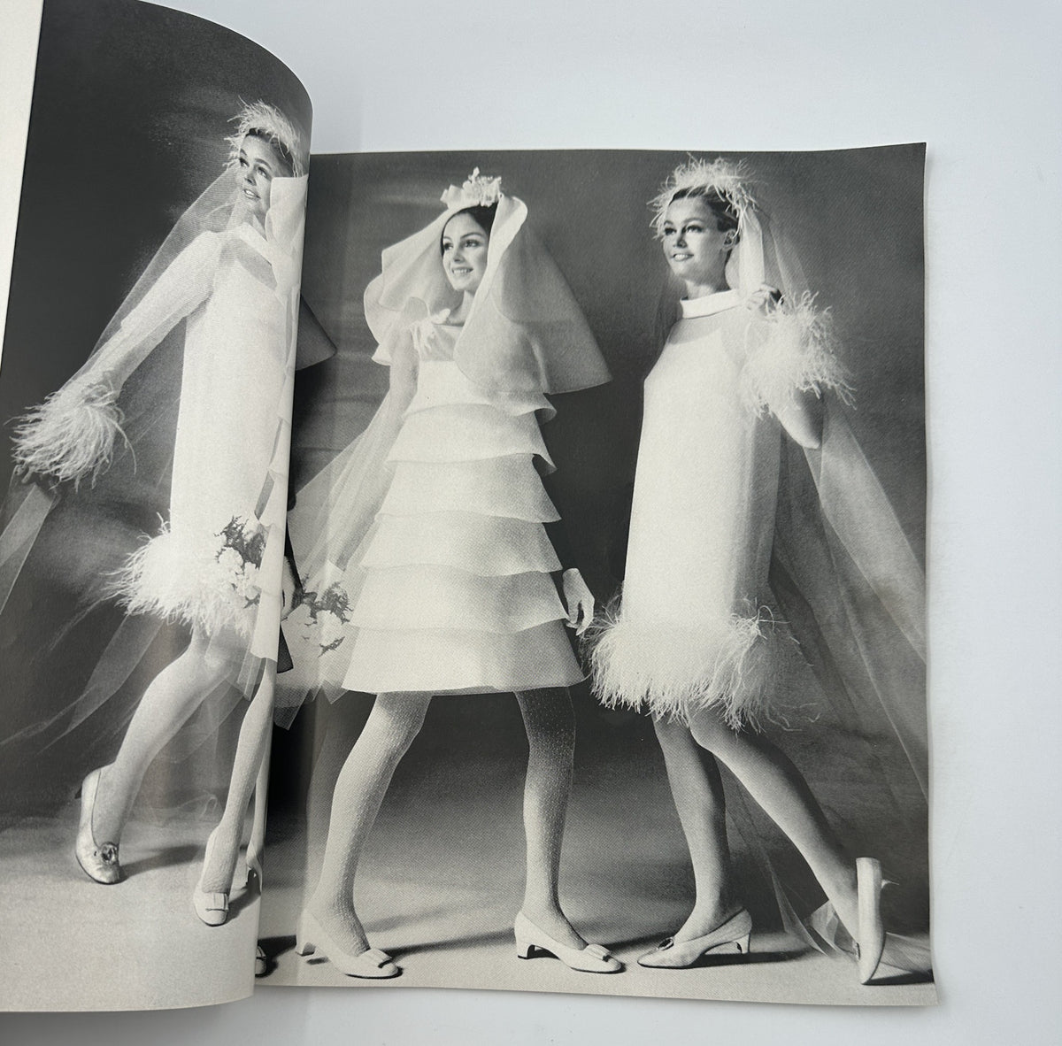 Stylish black and white photography of brides in Modern Bride Magazine April/May 1968, showcasing trendy wedding dresses with feather details.
