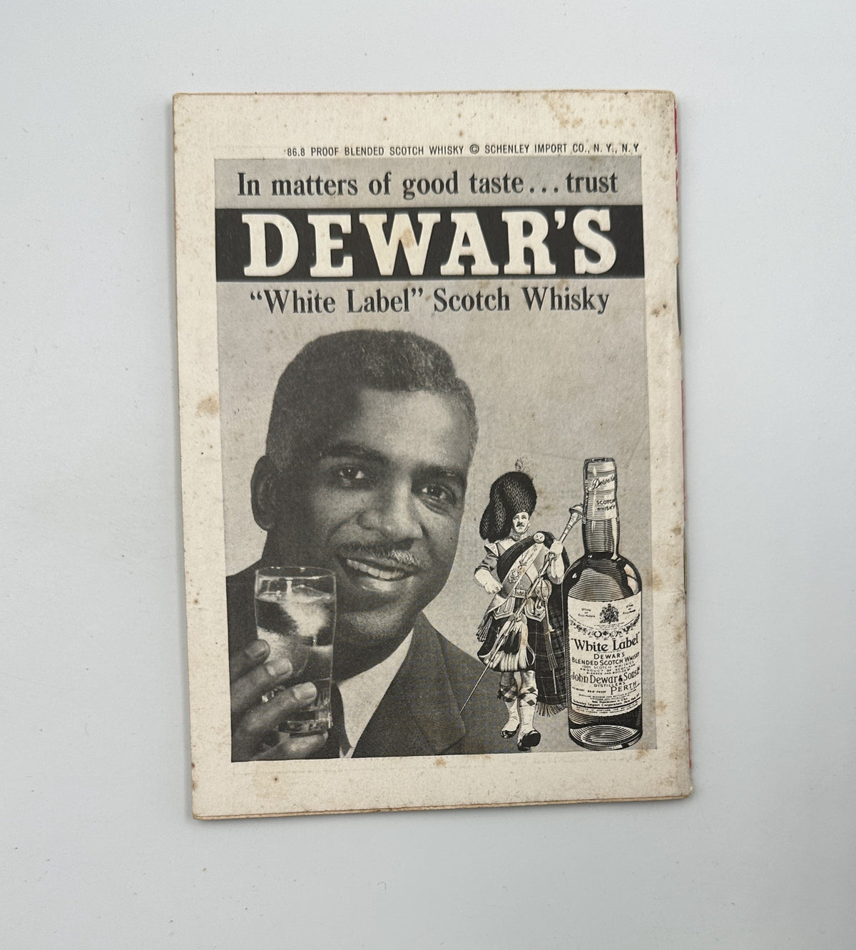 Advertisements page in Jet Magazine, featuring Dewar's 'White Label' Scotch Whisky, showcasing a man enjoying the drink, emphasizing quality and taste.