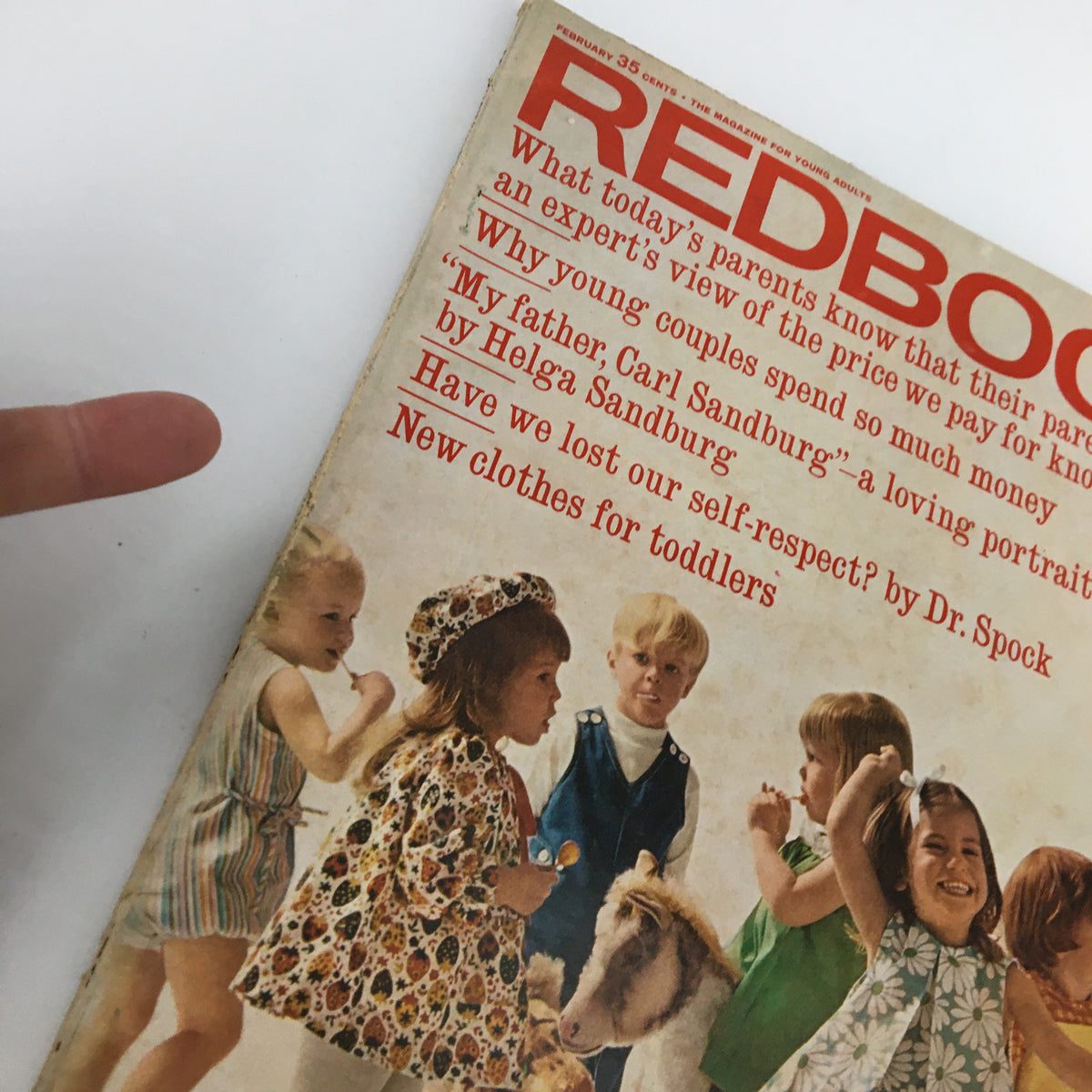 Zoomed-in view of the cover of VTG Redbook Magazine February 1966, showcasing children and editorial headlines such as 'Have we lost our self-respect?' and 'New clothes for toddlers.'