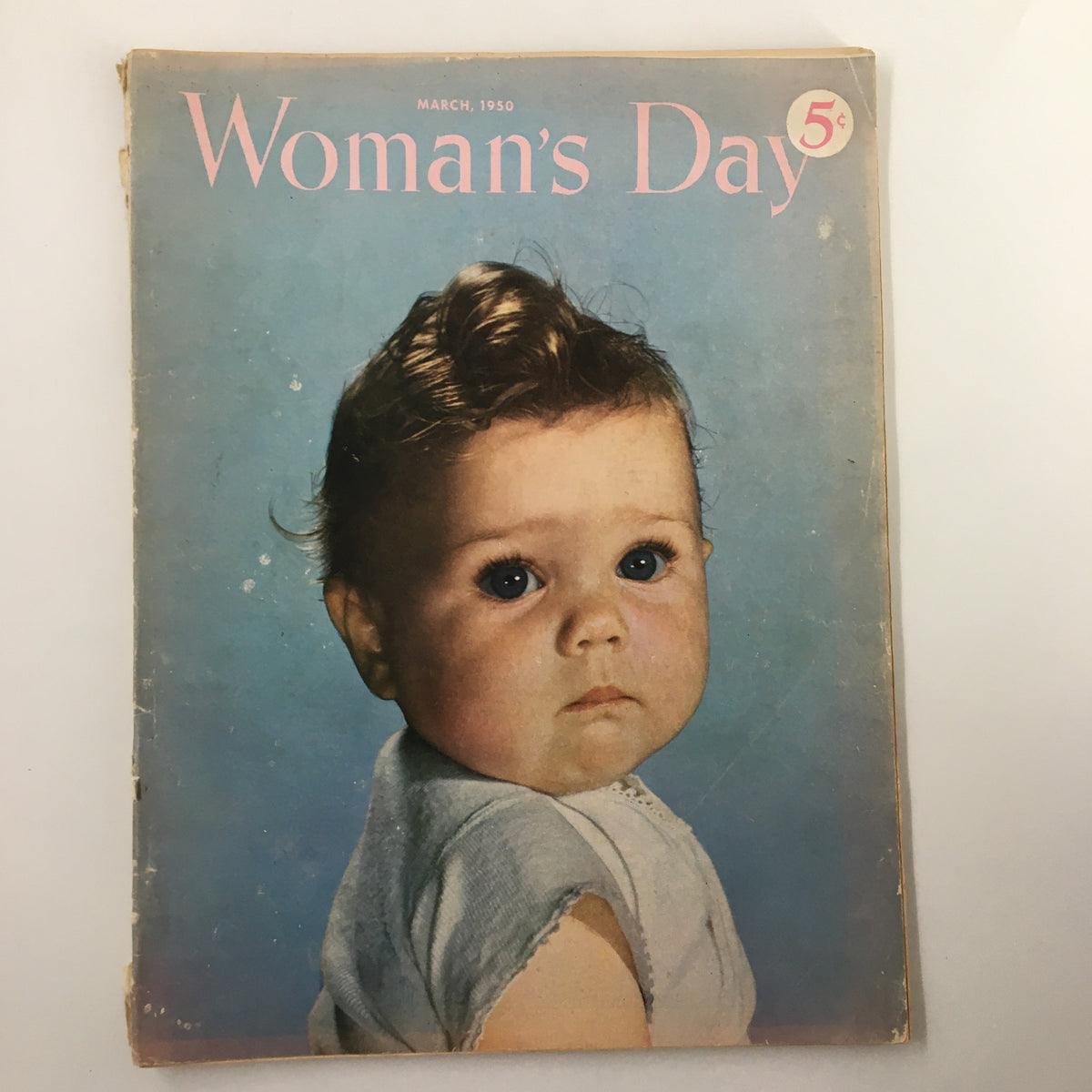 Vintage Woman's Day Magazine March 1950 cover featuring a baby with large blue eyes and wavy hair, depicting mid-century charm.