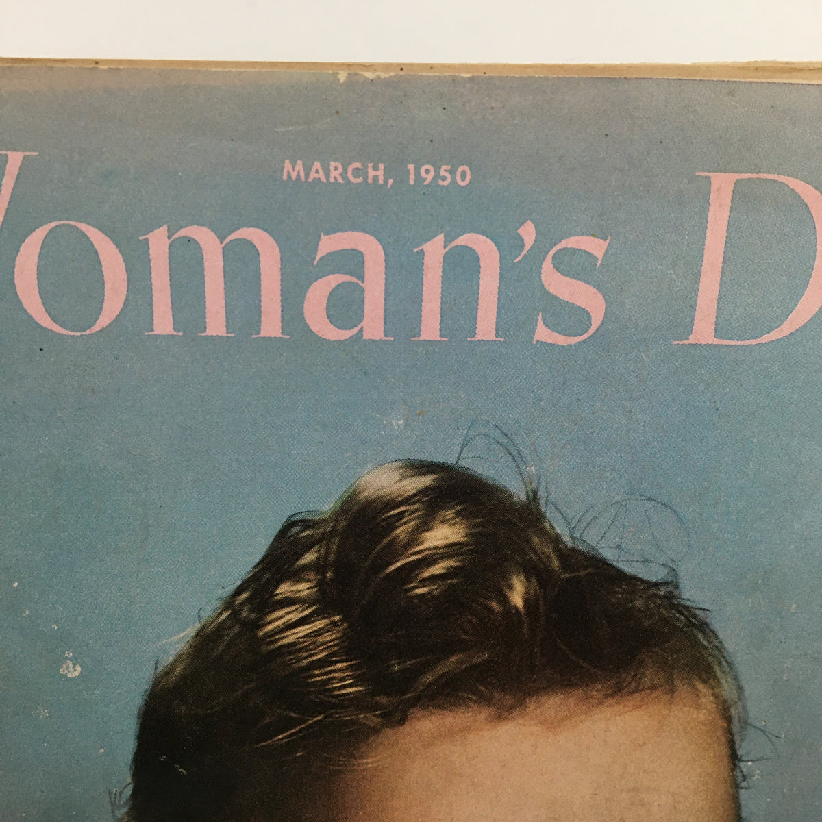 Front cover of the Vintage Woman's Day Magazine March 1950, displaying the magazine title against a pastel blue background with a child’s hair visible.