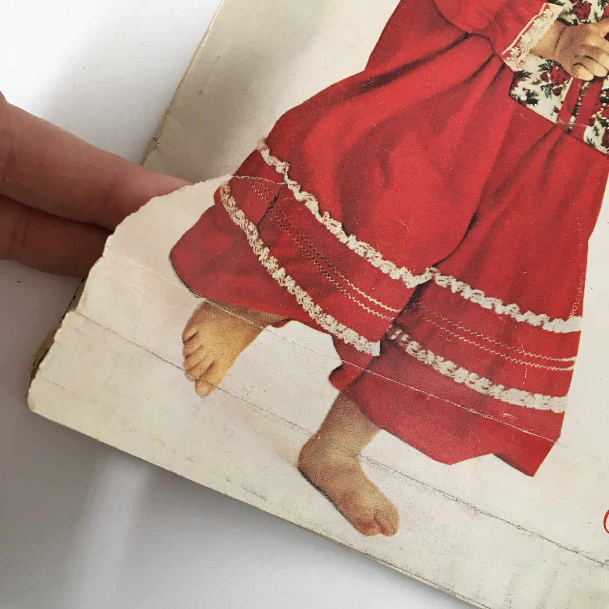 Close-up of Vintage Woman's Day Magazine December 1961 cover highlighting the lower section showing the girl's feet and the detail of her red dress, emphasizing the magazine's vintage appeal.