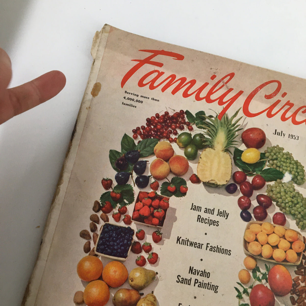 Close-up view of the cover of VTG Family Circle Magazine July 1953 with artsy fruit arrangement and text highlighting recipes and Navajo sand painting.