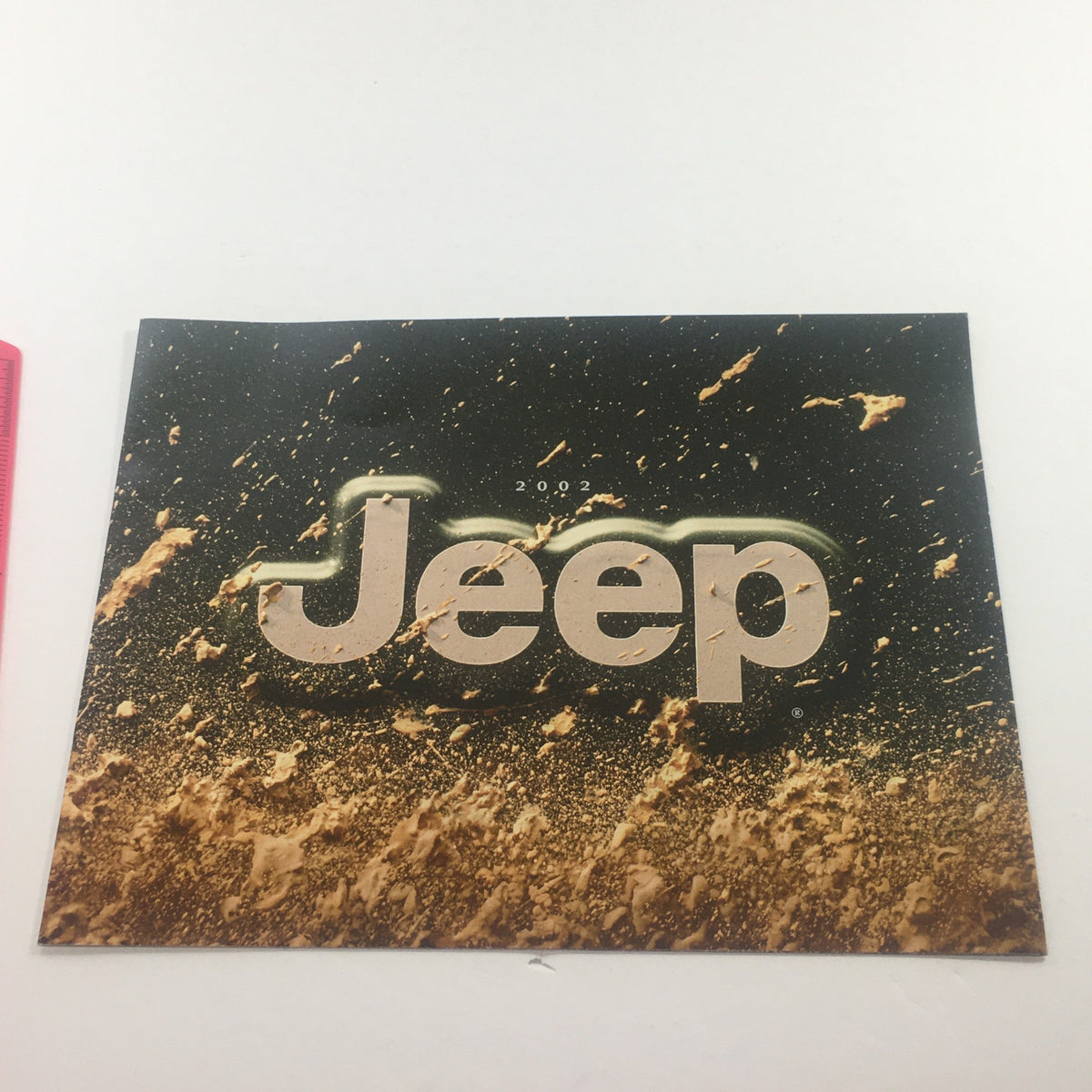 2002 Jeep Wrangler Sport Edition Dealership Car Auto Brochure Catalog cover featuring the Jeep logo and a splash of mud, emphasizing rugged outdoor adventure.