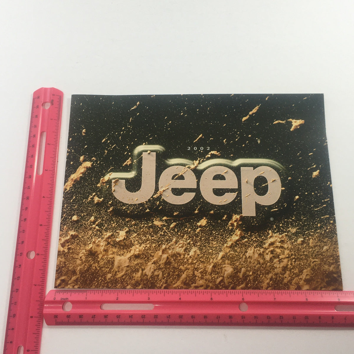 2002 Jeep Wrangler Sport Edition Dealership Car Auto Brochure Catalog cover showcasing the model name 'Jeep' against a splattered background, with a ruler for size reference.